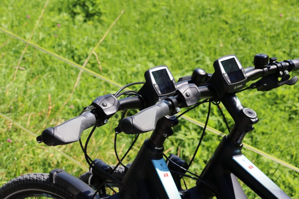 Zwei E-Bikes vor eine grünen Wiese