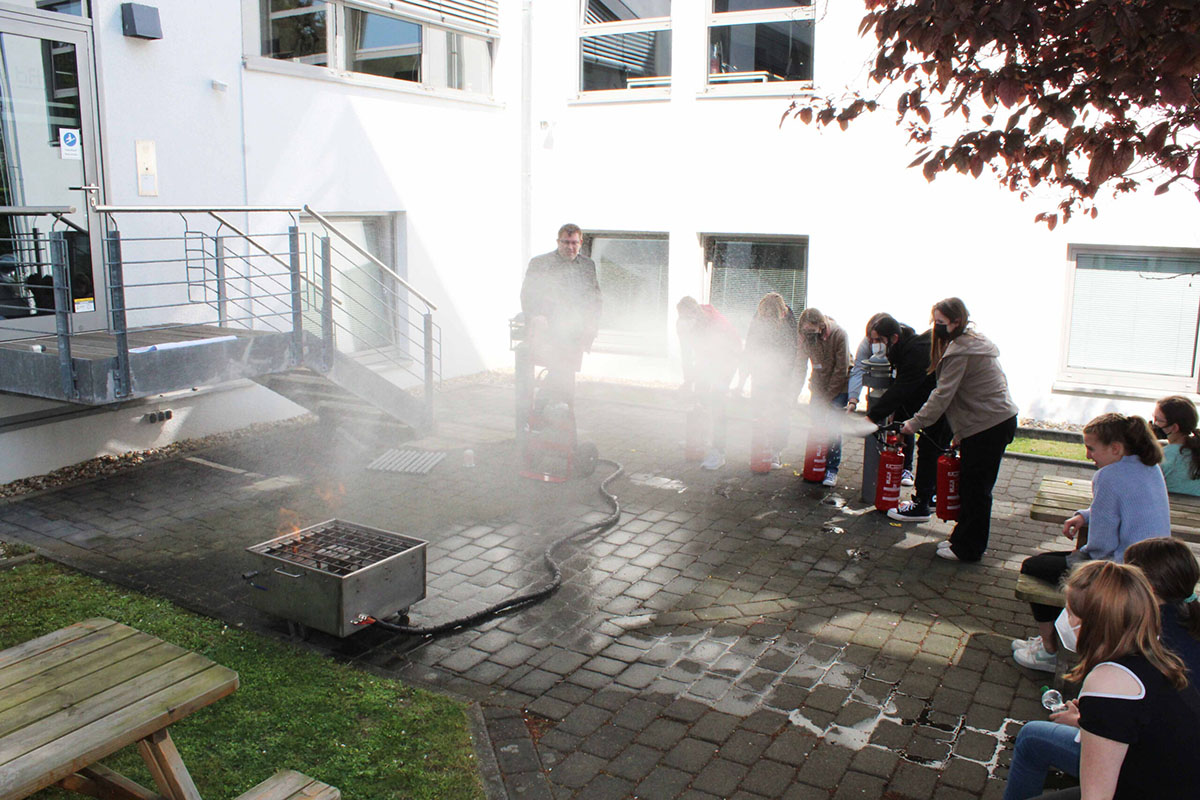Schülerinnen experimentieren mit einem Feuerlöscher bei einem Event der BFT Planung